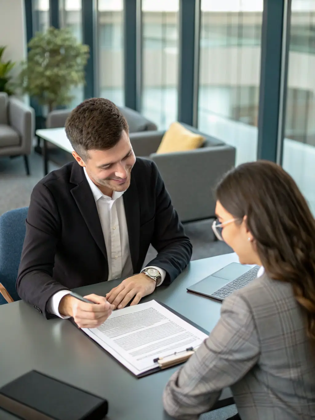 An image of a lawyer reviewing a contract with a client, with legal documents and a pen on the table.